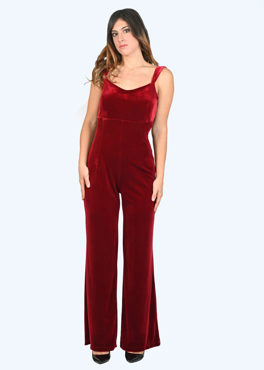Tuta intera in velluto Clizia color rosso ciliegia. Il velluto è morbido e confortevole. La scollatura a V lungo la schiena dona eleganza e raffinatezza alla tuta intera. Il modello è a vita alta con pantalone dalla linea scivolata. Tute intere eleganti e abbigliamento di lusso on line di alta qualità.