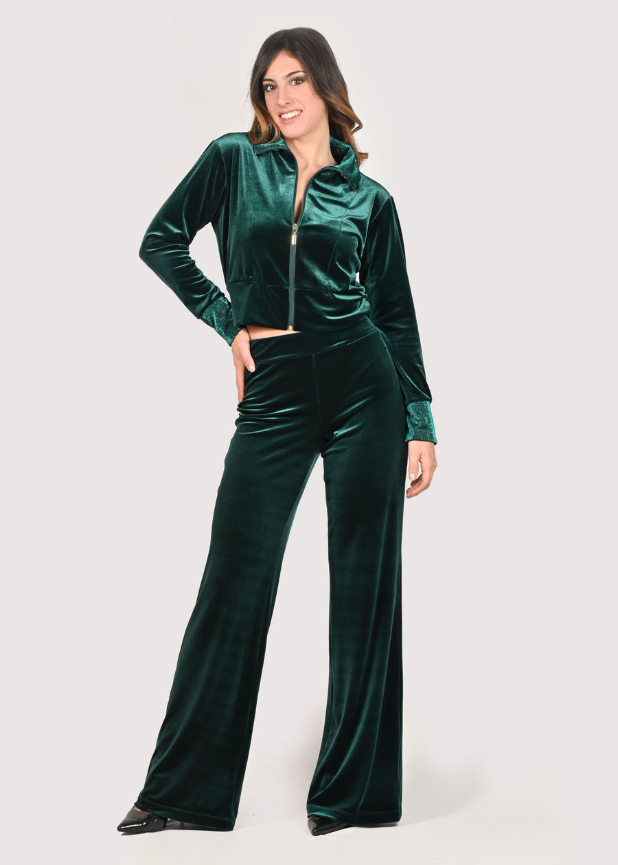 Tuta in velluto elegante verde con taglio crop e lurex tono su tono. La tuta senza cappuccio ha il collo ed i polsini in lurex. La felpa crop ha la cerniera lampo nichel free col oro, mentre il pantalone palazzo ha la baschina con l'elastico in vita, avvolgendo la silhouette femminile e slanciando la figura. Il tessuto elastico della tuta crop è morbido e confortevole. Le tute in velluto e le tute sportive eleganti sono un'ottima alternativa per sentirsi sempre comode ed trendy. 