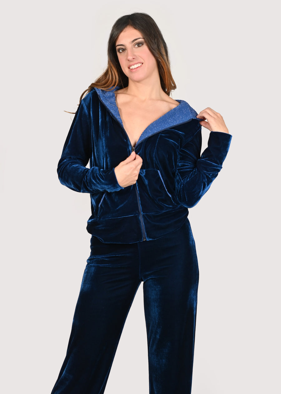 Tuta in velluto blu con inserti in lurex celeste. La felpa con cappuccio ha la cerniera lampo nichel free antracite. Il pantalone con elastico in vita è morbido e confortevole. Le tute in velluto e le tute da passeggio eleganti sono un'ottima alternativa per sentirsi sempre comode ed trendy. 