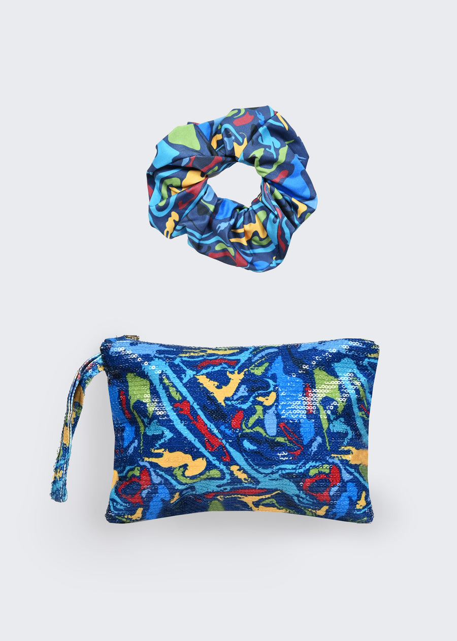 Set composto dallo scrunchie per capelli in jersey e dalla pochette in paillettes. Gli accessori sono realizzati in edizione limitata e riportano la stampa Millyblu “Meduse”. La pochette in paillettes è l'deale come pochette mare, ma anche come pochette gioiello nelle calde serate estive. Lo scrunchie per capelli aiuta a sostenere l’acconciatura.