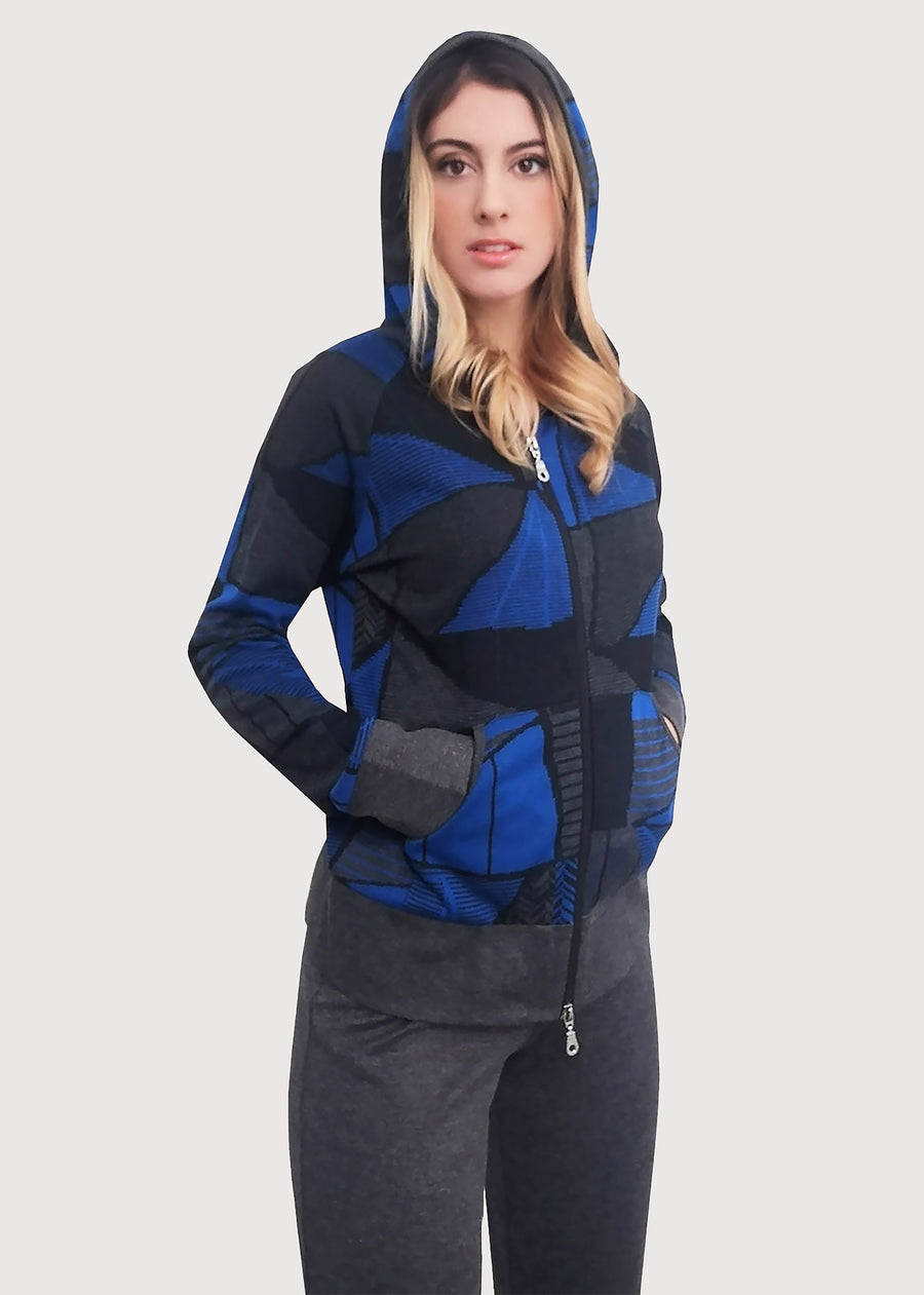 Tuta bluette in viscosa invernale con cappuccio. Giubbino dalla fantasia geometrica. Rifiniture grigie e chiusura con zip. Completo con pantalone grigio dritto in viscosa invernale. L'elastico inserito in vita permette una buona vestibilità.