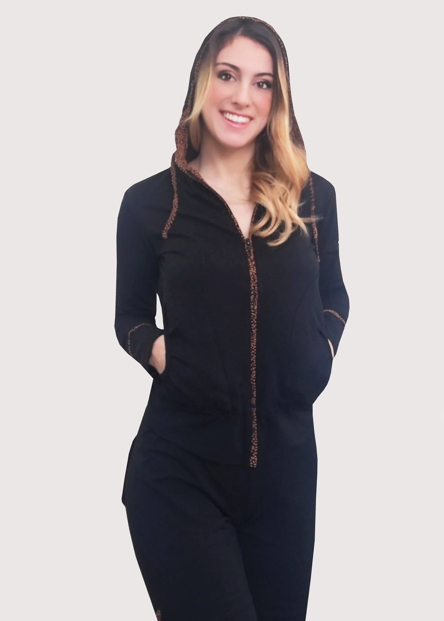 Tuta Completo nera in cotone elastico, morbido e confortevole. La felpa con cappuccio ha la cerniera lampo. Il cappuccio e i buddelini riportano una fantasia delicata. Il pantalone morbido ha le tasche posteriori e i budellini fantasia inseriti lateralmente, con l'elastico in vita e coulisse regolabile alla caviglia.