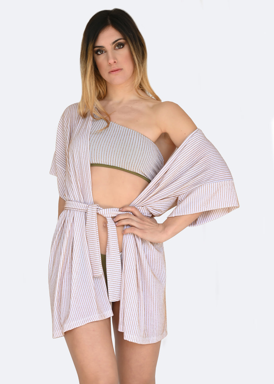 Cardigan bianco in lurex a righe oro. Ha la manica larga e la cinta in vita. Confortevole, fresco e morbido. Comodo per le lunghe giornate estive anche come copricostume mare o fuori acqua.