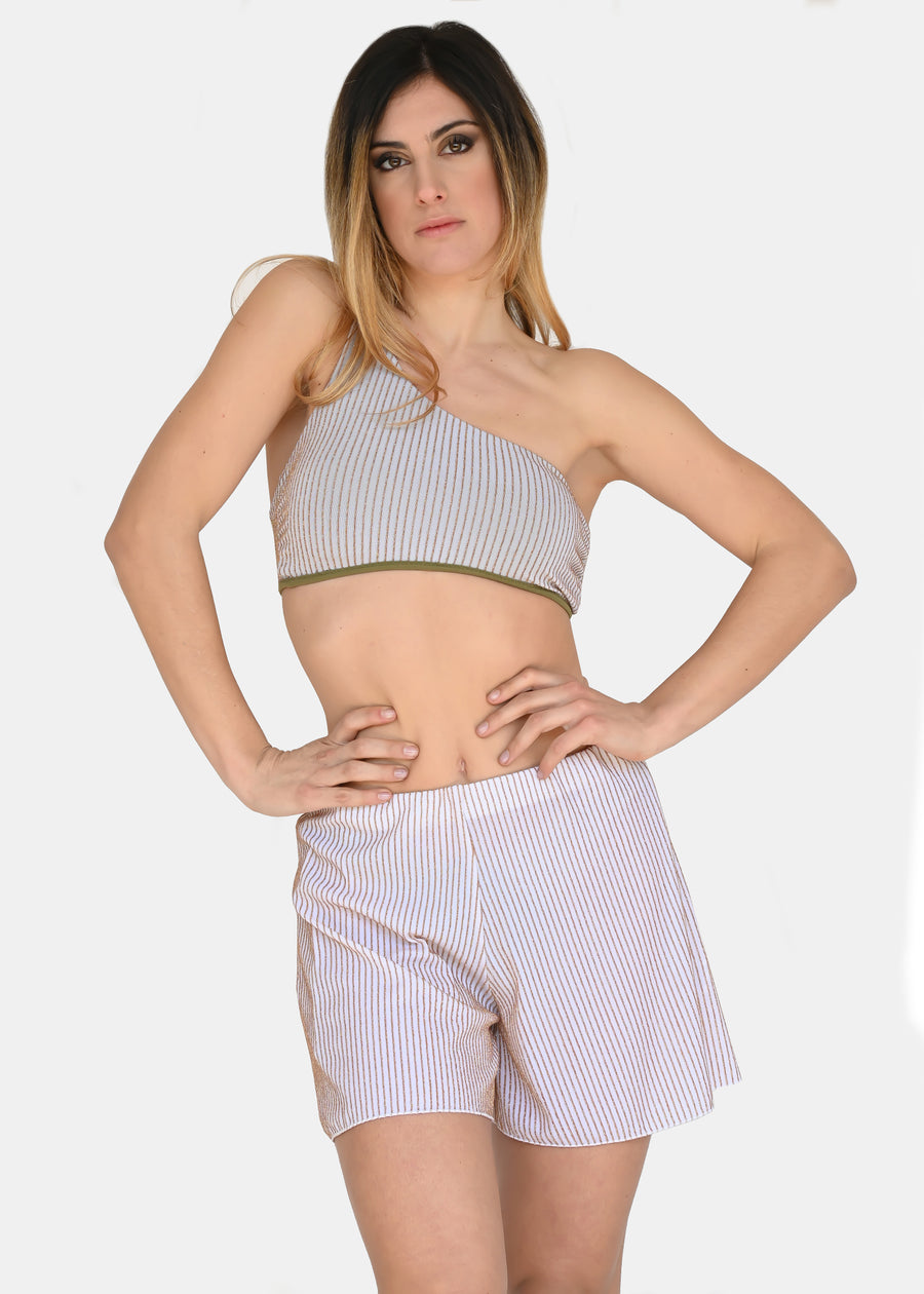 Pantaloncino bianco a righe oro. Confortevole, fresco e morbido. Ha l'elastico in vita con cuciture laterali. È possibile indossarlo sia a vita bassa che a vita alta. Comodo per le lunghe giornate estive anche come copricostume mare o fuori acqua.