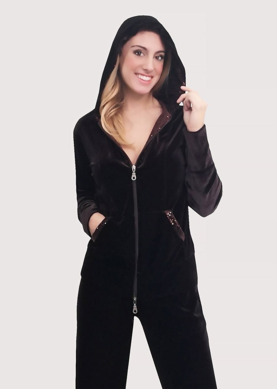 Tuta Completo in velluto moro con tasche e interno del cappuccio in paillettes tono su tono. La felpa con cappuccio ha la cerniera lampo, mentre il pantalone con elastico in vita è dritto, dalla linea scivolata. Il tessuto elastico è morbido e confortevole. 