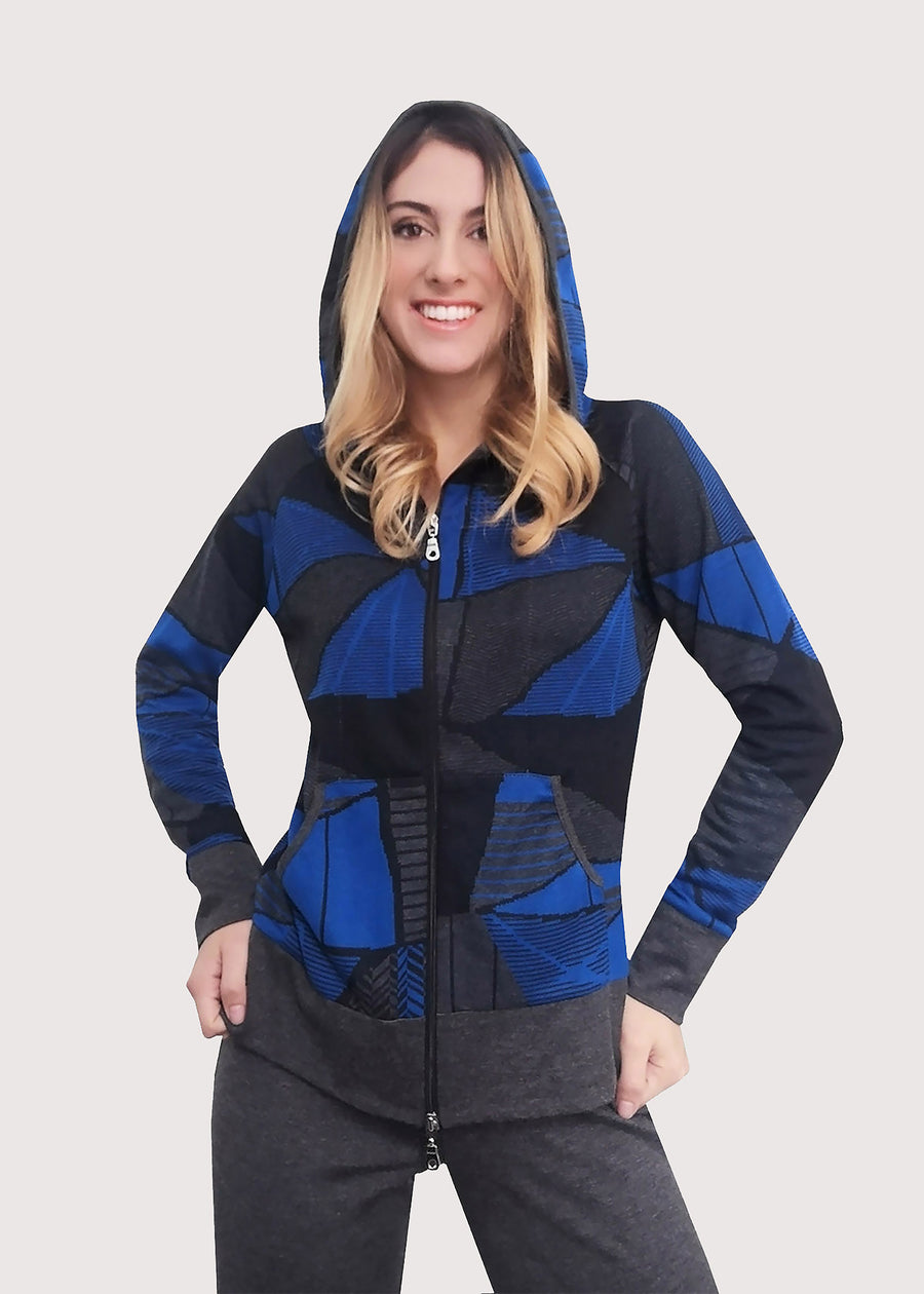 Tuta bluette in viscosa invernale con cappuccio. Giubbino dalla fantasia geometrica. Rifiniture grigie e chiusura con zip. Completo con pantalone grigio dritto in viscosa invernale. L'elastico inserito in vita permette una buona vestibilità.