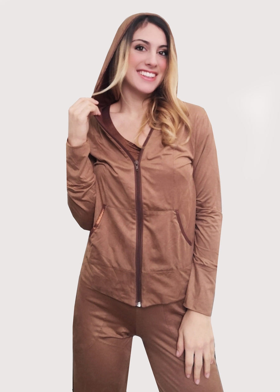 Tuta Sportiva Elegante in dainetto stretch con inserti satinati sui toni del cuoio e inserti in maglina satinata nel cappuccio e lungo i bordi delle tasche. La tuta completo comprende giubbino, maglia a maniche corte e pantalone. Il pantalone con elastico in vita ha le tasche con taglio a mezzaluna e le coulisse regolabili alla caviglia.