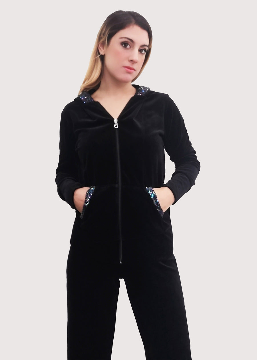 Tuta Completo in ciniglia nera sporty chic. La felpa con cappuccio è rifinita internamente e ha gli inserti in paillettes sul cappuccio e sulle tasche. Il pantalone morbido ha un'ottima vestibilità, con l'elastico in vita e la coulisse nell'orlo, per poter regolare la lunghezza del pantalone come si preferisce.