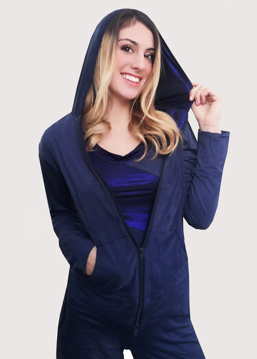 Tuta Completo in dainetto stretch con inserti in maglina satinata blu nel cappuccio e lungo i bordi delle tasche. La tuta completo comprende giubbino, maglia a maniche corte e pantalone. Il pantalone con elastico in vita ha le tasche con taglio a mezzaluna e le coulisse regolabili alla caviglia.