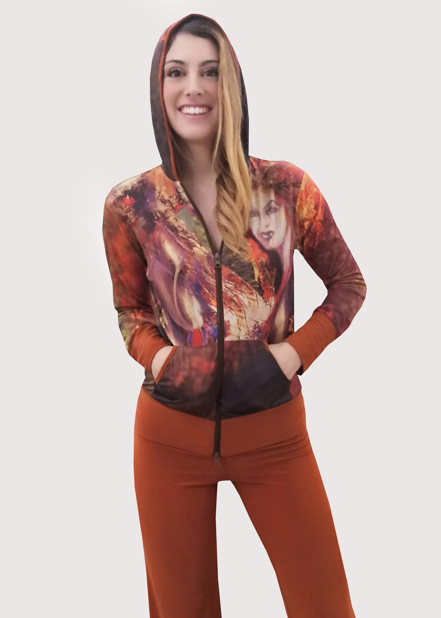 Tuta in maglina color coccio con cappuccio. Il giubbino riporta una delle nostre stampe, dal dipinto "Futura". Il pantalone è a tinta unita con la baschina doppiata e l'elastico in vita, dalla linea semplice e leggermente svasata in fondo. Particolare ed elegante nella sua essenza.