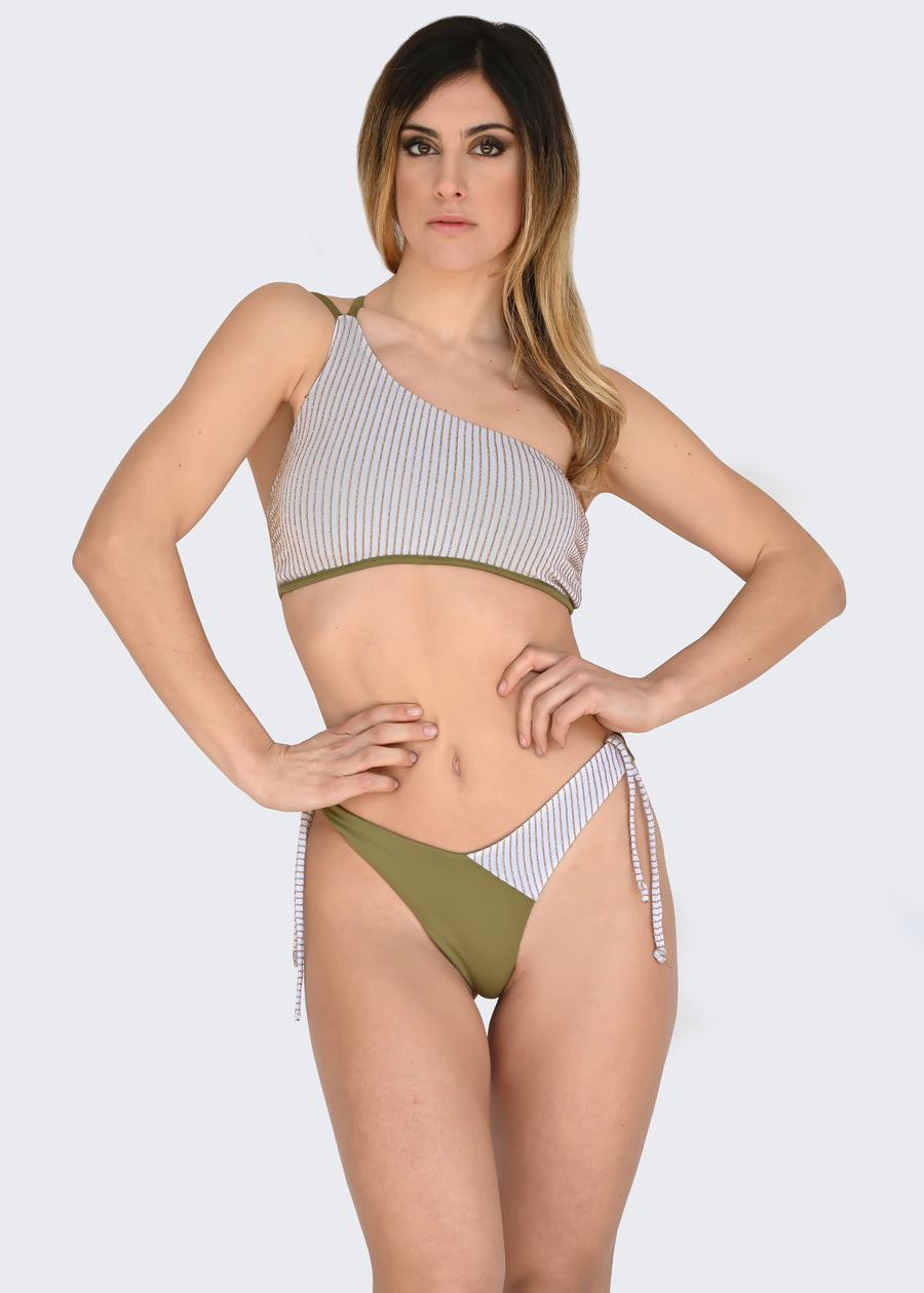 Bikini monospalla in microfibra verde militare e panna con righe oro in lurex. Il top monospalla è a fantasia e ha la doppia bretellina a tinta unita. Il costume sgambato ha lo slip a brasiliana ed i laccetti removibili con inserto a fantasia. I tessuti elastici permettono un'asciugatura rapida. I costumi monospalla sono il must have dell'estate. L'ideale come costume da bagno per il mare o per la piscina.