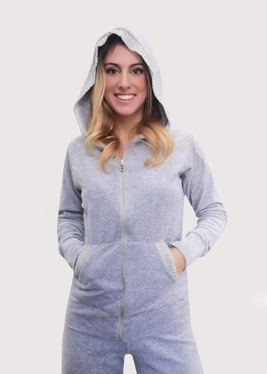 Tuta Completo in ciniglia grigia con inserti sulle tasche. La felpa con cappuccio è doppiata in maglina satinata cangiante. La tuta elegante ha la cerniera lampo. Il pantalone morbido ha l'elastico in vita e la coulisse all'orlo. 