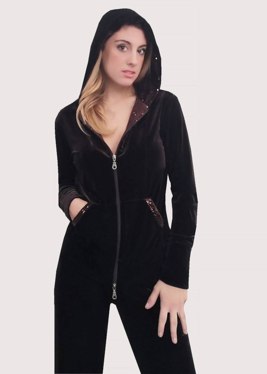 Tuta Completo in velluto moro con tasche e interno del cappuccio in paillettes tono su tono. La felpa con cappuccio ha la cerniera lampo, mentre il pantalone con elastico in vita è dritto, dalla linea scivolata. Il tessuto elastico è morbido e confortevole. 