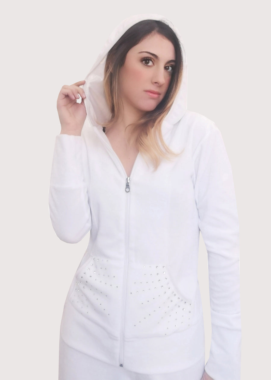Tuta Completo bianca in ciniglia con strass sulle tasche. La felpa con cappuccio è doppiata in maglina satinata cangiante. La tuta elegante ha la cerniera lampo. Il pantalone morbido ha l'elastico in vita e la coulisse all'orlo. 