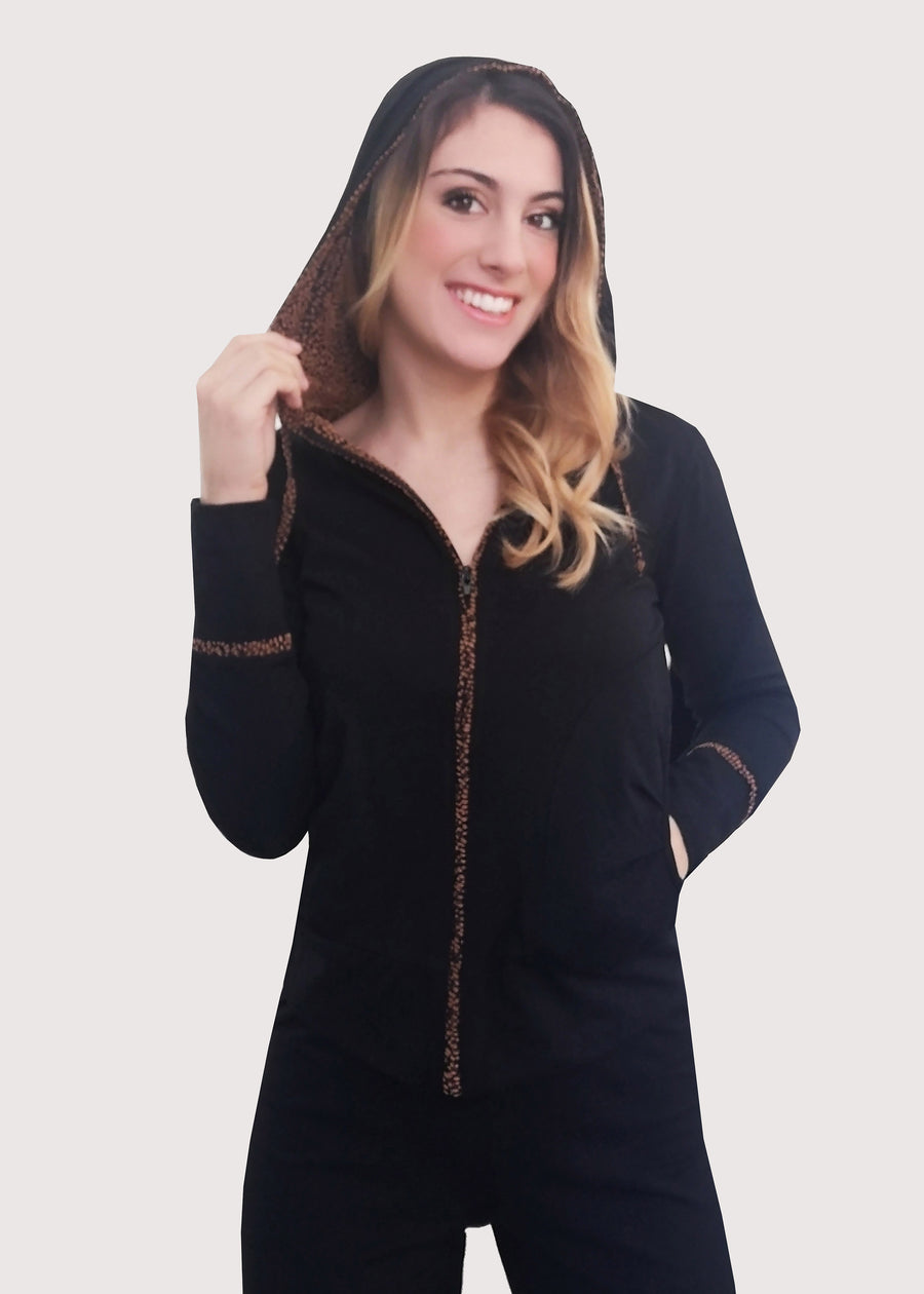 Tuta Completo nera in cotone elastico, morbido e confortevole. La felpa con cappuccio ha la cerniera lampo. Il cappuccio e i buddelini riportano una fantasia delicata. Il pantalone morbido ha le tasche posteriori e i budellini fantasia inseriti lateralmente, con l'elastico in vita e coulisse regolabile alla caviglia.