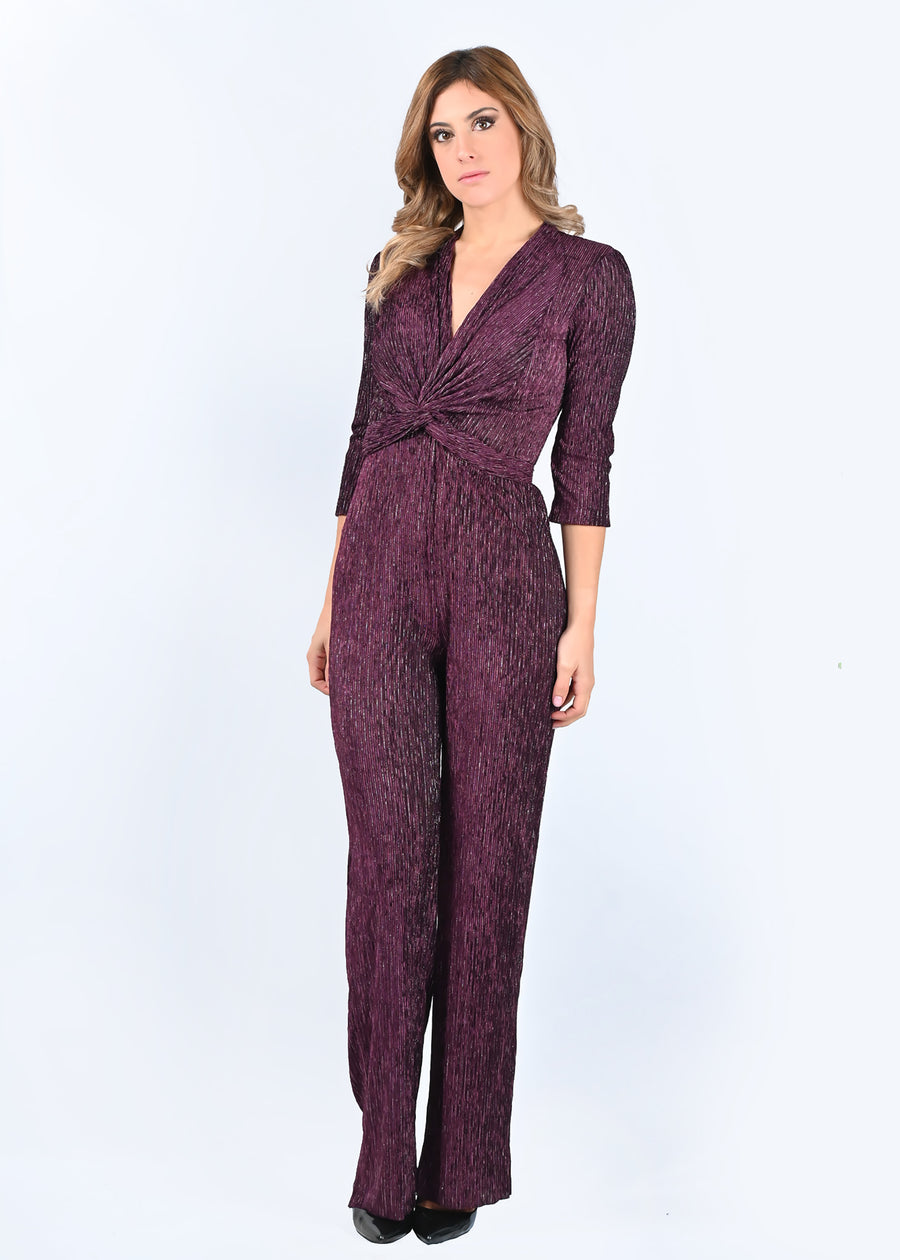 Tuta intera elegante Margherita in tessuto goffrato viola. La scollatura è a V, con nodo centrale regolabile. La manica della tuta è a 3/4. Il modello è a vita alta con pantalone dalla linea scivolata.