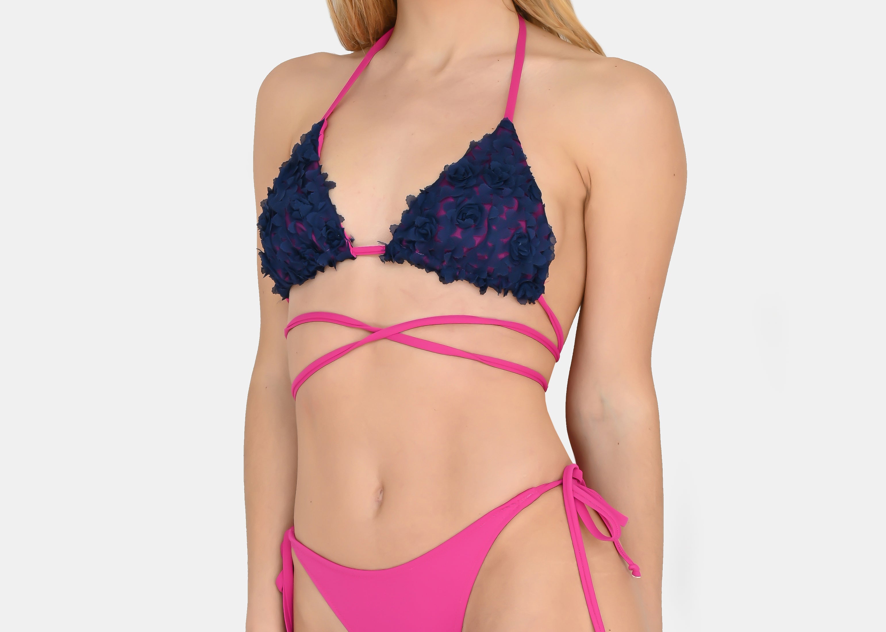 Bikini in microfibra fucsia con pizzo blu. Il triangolo si lega dietro al collo e i budellini sul torace donano sensualità alla silhouette femminile. Lo slip ha i laccetti laterali. Il bikini è composto da tessuti elastici di rapida asciugatura e donano massimo comfort a chi lo indossa.