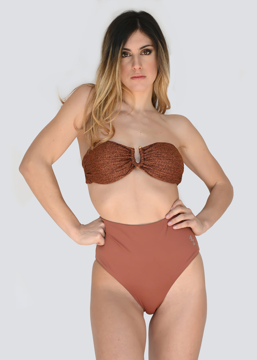Bikini a fascia coccio e lurex bronzo con fodera e laccetti coccio, dai dettagli chic e sofisticati. La fascia è impreziosita da un anello centrale a "U" color oro nichel free, coppe estraibili e laccetti elastici che possono essere annodati dietro al collo, ma anche utilizzati come bretelline. Lo slip a vita alta double face e può essere utilizzato anche ripiegandolo su se stesso.